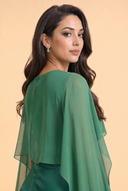 Chiffon Dream Modest Evening Dress in Emerald Green — over-shoulder back profile portrait, intimate editorial close-up — modeled without hijab — modest evening fashion for all — Mystic Modesty premium hijab fashion brand.