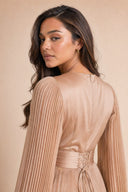 Modest Pleated Satin Gown in Champagne Cream — over-shoulder back profile portrait, intimate editorial close-up — modeled without hijab — modest evening fashion for all — Mystic Modesty premium hijab fashion brand.