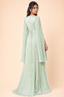 Modest Pleated Satin Gown in Mint Green — three-quarter back angle with gentle over-shoulder glance — modeled without hijab — modest evening fashion for all — Mystic Modesty modest formal wear for women.
