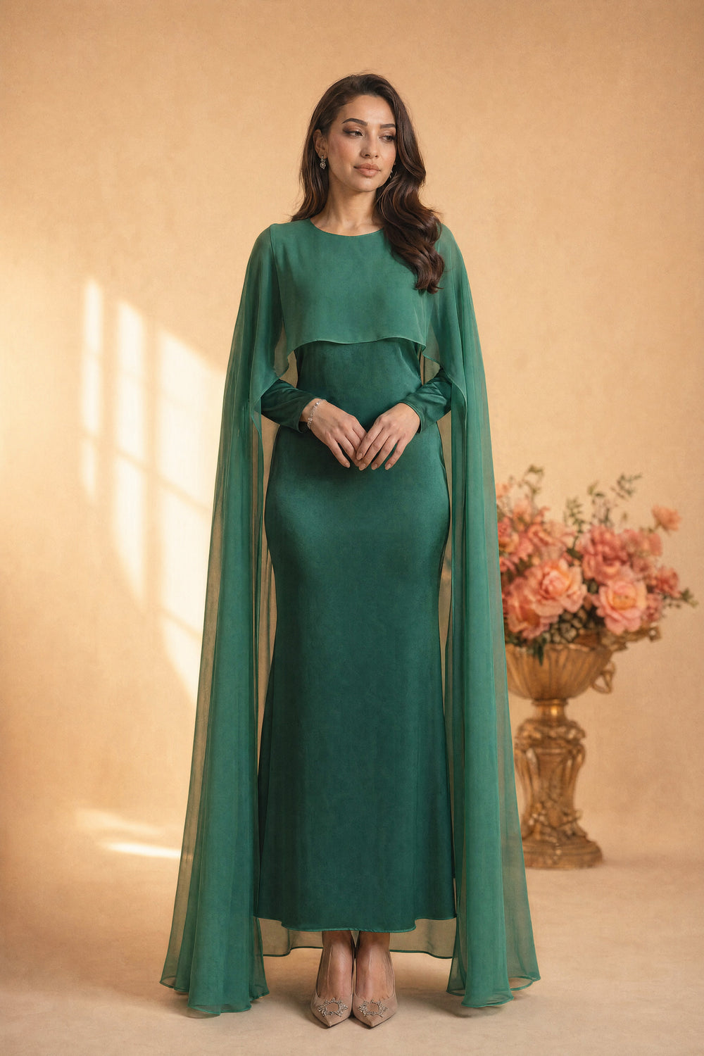 Mystic Modesty SS26— Yasmine Emerald chiffon cape gown, studio portrait against cream backdrop with coral peonies, non-hijabi model, modest evening wear, Vogue editorial film aesthetic