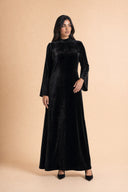 Velvet Elegance Modest Abaya Dress in Deep Black — editorial quiet moment, contemplative pose — modeled without hijab — modest evening fashion for all — Mystic Modesty modest evening dress.