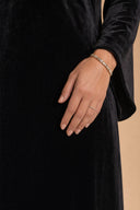 Velvet Elegance Modest Abaya Dress in Deep Black — ultra-macro detail of premium fabric texture, sheen, and refined jewelry — modeled without hijab — modest evening fashion for all — Mystic Modesty premium modest evening wear.