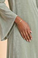 Velvet Elegance Modest Abaya Dress in Forest Green — ultra-macro detail of premium fabric texture, sheen, and refined jewelry — modeled without hijab — modest evening fashion for all — Mystic Modesty premium modest evening wear.