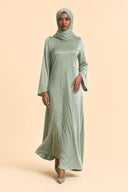 Velvet Elegance Modest Abaya Dress in Forest Green — captured in natural stride showing fabric flow and movement — modeled with hijab — Islamic modest styling — Mystic Modesty modest occasion gown.