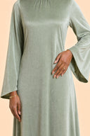 Velvet Elegance Modest Abaya Dress in Forest Green — mid-body view showing waist construction and elegant jewelry detail — modeled without hijab — modest evening fashion for all — Mystic Modesty modest occasion gown.
