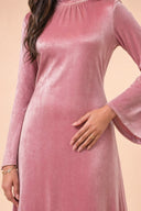 Velvet Elegance Modest Abaya Dress in Rose Pink — mid-body view showing waist construction and elegant jewelry detail — modeled without hijab — modest evening fashion for all — Mystic Modesty modest occasion gown.