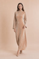 Velvet Elegance Modest Abaya Dress in Warm Beige — captured in natural stride showing fabric flow and movement — modeled without hijab — modest evening fashion for all — Mystic Modesty modest evening fashion.