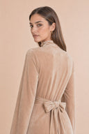 Velvet Elegance Modest Abaya Dress in Warm Beige — over-shoulder back profile portrait, intimate editorial close-up — modeled without hijab — modest evening fashion for all — Mystic Modesty premium hijab fashion brand.